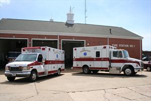 Two Ambulances Parked Outside Fire Station